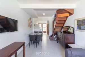 a living room with a staircase and a dining room at Linda Casa em Cabo Frio PTB0105 in Peró