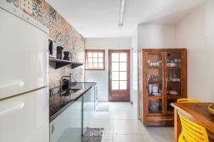 a kitchen with a refrigerator and a counter top at Linda Casa em Cabo Frio PTB0105 in Peró