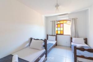 a small room with two beds and a window at Linda Casa em Cabo Frio PTB0105 in Peró +15 photos