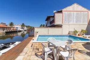 a house with a swimming pool and a table and chairs at Linda Casa em Cabo Frio PTB0105 in Peró