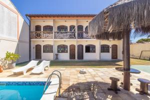 an external view of a villa with a swimming pool at Linda Casa em Cabo Frio PTB0105 in Peró