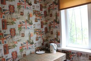 a bathroom with a wall covered in british newspapers at Новый Люкс в центре города по Алиханова in Karagandy