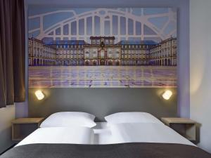 曼海姆B&B Hotel Mannheim-Neuostheim的房间里有两张床，还有一张卢浮宫的照片