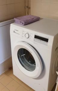 a white washing machine with a purple towel on top at Studio with sauna in the center in Laitila