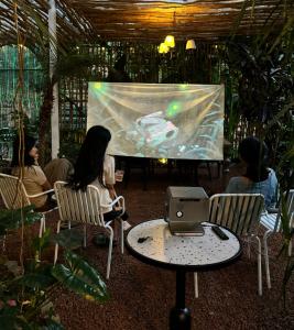 a group of people sitting in chairs watching a screen at Hè Maison Retreat in Teurnoum