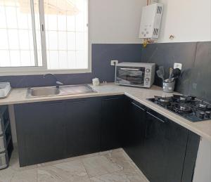 a kitchen with a sink and a microwave at La Marsa charming house Marsa in Tunis +15 photos