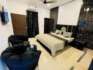 a bedroom with a bed and two chairs at Family Signature Residency in Lahore