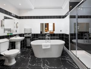 a bathroom with a tub and a toilet and a sink at Albany Hotel in Edinburgh