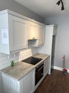 a kitchen with white cabinets and a counter top at Fado apartment 2 in Bantry