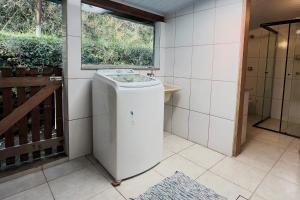 una lavatrice in un bagno con finestra di Casa do Lago - Cochicho das Águas a Mairiporã Altre 47 foto