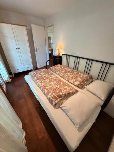 a bedroom with a bed with a wooden floor at Alpine Haven Chalet II in Iseltwald