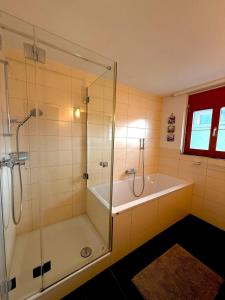 a bathroom with a shower and a bath tub at Alpine Haven Chalet II in Iseltwald +28 photos