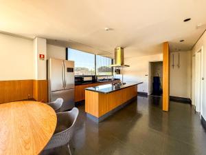 Una cocina con una mesa de madera y un refrigerador. en Vista livre, suíte de luxo, Apartamento de Luxo, en Brasilia