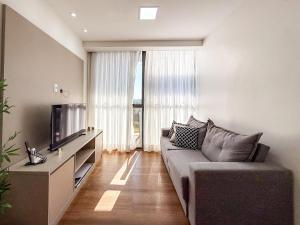 Una sala de estar con un sofá y un televisor. en Vista livre, suíte de luxo, Apartamento de Luxo, en Brasilia