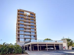un edificio alto con un coche aparcado delante de él en Vista livre, suíte de luxo, Apartamento de Luxo, en Brasilia