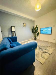 a living room with a blue couch and a tv at Walsall Comfort Home 3Bedroom Retreat Sleeps 6 in Bescot