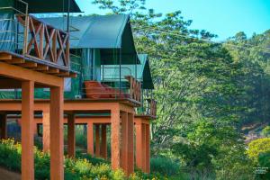 a green house with a balcony on top of it at Train View Chalet in Bandarawela