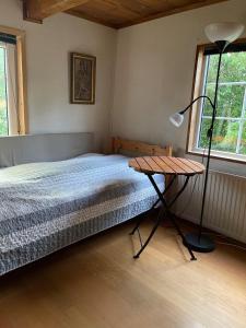 a bedroom with a bed with a lamp and a table at Gunilla's house in Huaröd in Huaröd