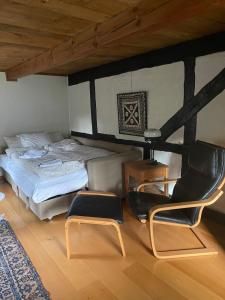 a bedroom with a bed and two chairs in it at Gunilla's house in Huaröd in Huaröd