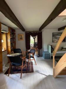 a living room with a table and chairs and a staircase at Gunilla's house in Huaröd in Huaröd