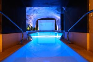a swimming pool in a building with blue lighting at 24th Floor Luxury Sea View Apart-Hotel Pools Spa Gym & Rooftop I Mercury Tower in St. Julianʼs