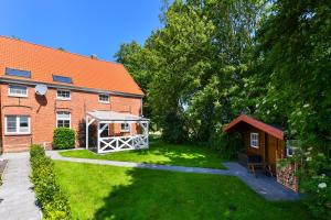 una casa con un patio con cenador en Ferienwohnung Landleben am Meer, en Bensersiel