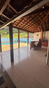 a pavilion with a table and chairs in a building at Casa em São Tomé das Letras in São Thomé das Letras