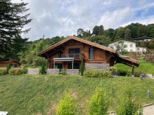 a large wooden house on a grassy field at Le Chalet Margaux La Bresse in La Bresse