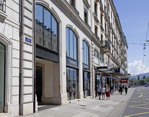 a group of people walking down a street in front of buildings at Appartement Centre Ville in Geneva