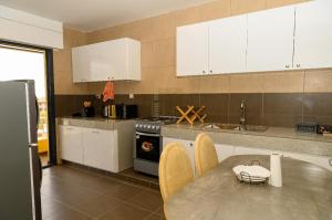 a kitchen with white cabinets and a table with chairs at Spacious & bright bedroom in Dakar