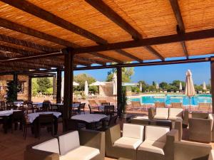 un patio avec tables et chaises et une piscine dans l'établissement Villa Amaranta - Is Molas, à Is Molas 
