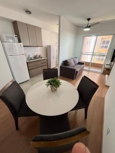 a kitchen and living room with a table and chairs at Apartamento novo, mobiliado e com ótima localização in Barretos
