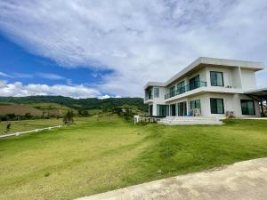 a large white house with a large grass yard at Cloud N Wind Khao Kho Thailand in Ban Lao Kok Kho