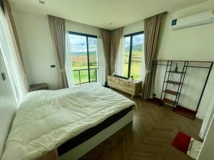 a bedroom with a large bed with a large window at Cloud N Wind Khao Kho Thailand in Ban Lao Kok Kho
