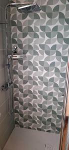 a bathroom with a shower with a checkered wall at San Paolo Hideout in Rome
