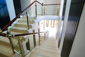 a staircase in a house with a glass railing at Sherline Hotel in Urganch