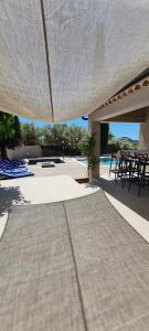 a patio with a table and chairs under a white umbrella at Chambre indépendante vue vignes et mer in Saint-Cyr-sur-Mer