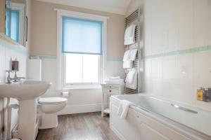 a bathroom with a sink and a toilet and a tub at The Brewer's House in Southwold +6 photos