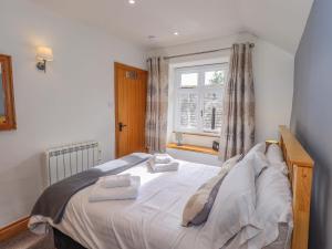 a bedroom with a bed with two towels on it at Boxwood Cottage in Troutbeck