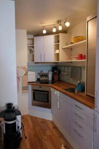 eine Küche mit weißen Schränken und einer Spüle in der Unterkunft 1 12 Zi Wohnung mit persönlichem Charme - b48574 in Vulpera