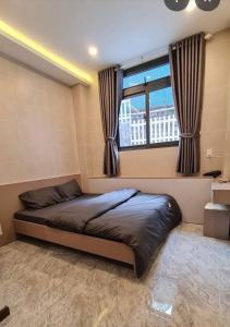 a bed in a room with a large window at Một Chiều Mưa Lang Thang in Xuan An