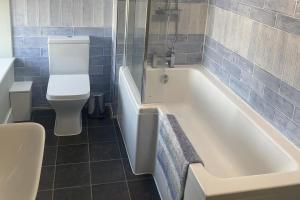a bathroom with a white tub and a toilet at Teviot Cottage 7 Fenton Hill Farm in Wooler