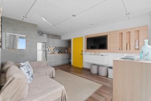a living room with a couch and a kitchen at Beachfront Oceanview Wifi Self Check in in San Juan