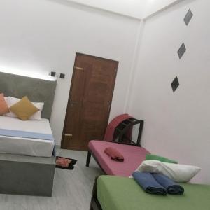 a small room with two beds and a door at Rooms in galle in Galle