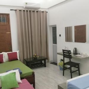 a room with a bed and a table and a chair at Rooms in galle in Galle