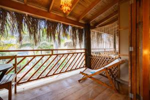 a porch with a bench and a chandelier at Hospedaje La Quebrada in Máncora +129 photos