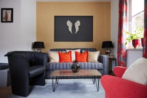 sala de estar con sofá gris y almohadas de color naranja en Upland-Flair Ferienwohnung ABENDROT im Zentrum!, en Willingen