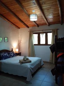 ein Schlafzimmer mit einem Bett und einer Holzdecke in der Unterkunft La Margarita in Villa Ciudad Parque