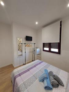 a bedroom with a bed with two towels on it at 1º IZQ H-1 vistas al mar in Vigo +1 photo