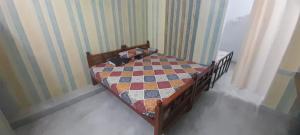 a bedroom with a bed with a quilt on it at Mahadev Residency in Tiruvannāmalai +4 photos